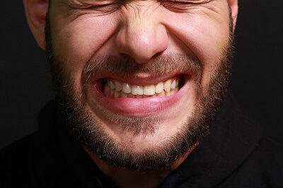 Man with beard grinding teeth